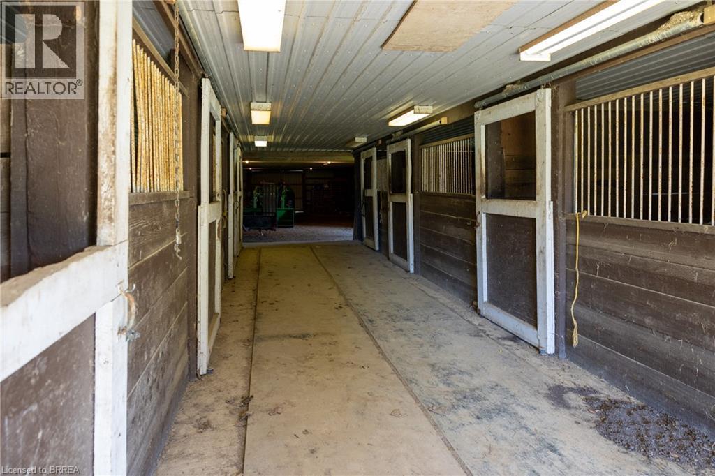 Barn interior featuring multiple stalls with wood construction and white trim - 269 Brant County Road 22, Ancaster, ON - With Exterior