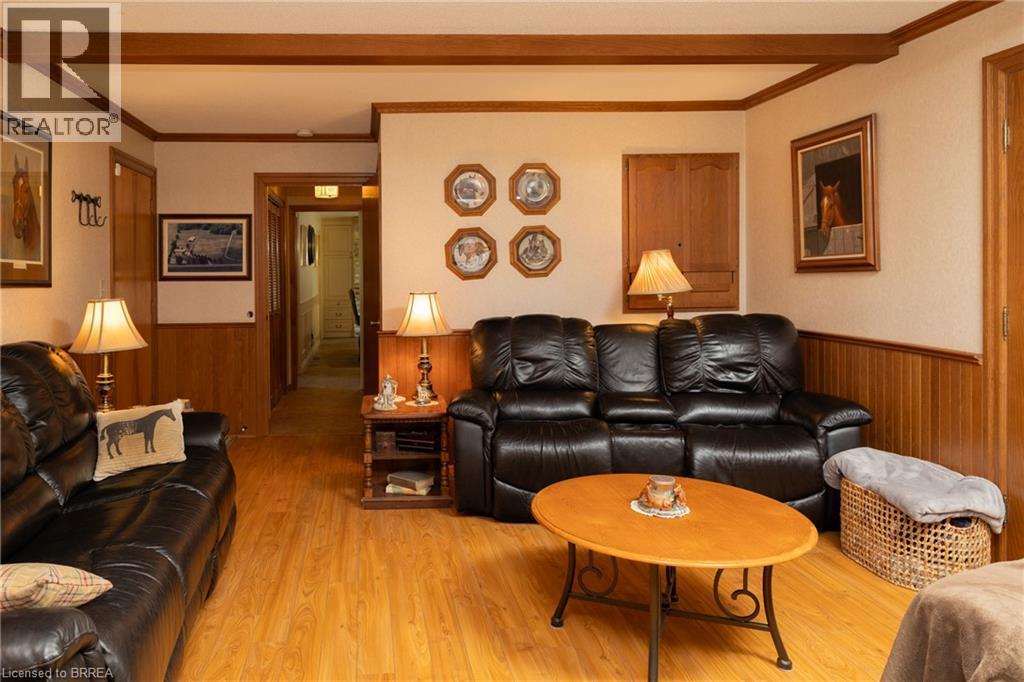 Living area featuring light wood-finish flooring, wood panel wainscoting, and exposed ceiling beams - 269 Brant County Road 22, Ancaster, ON - Indoor Photo Showing Living Room
