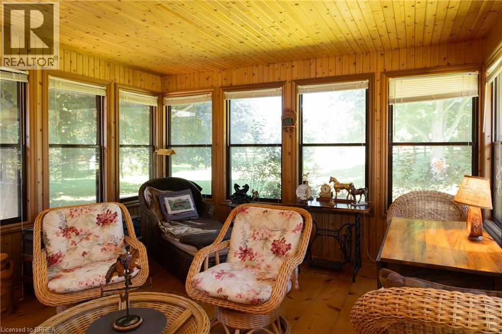 Sunroom featuring extensive natural wood plank walls and ceilings, numerous windows, and wood-finish flooring - 269 Brant County Road 22, Ancaster, ON - Indoor