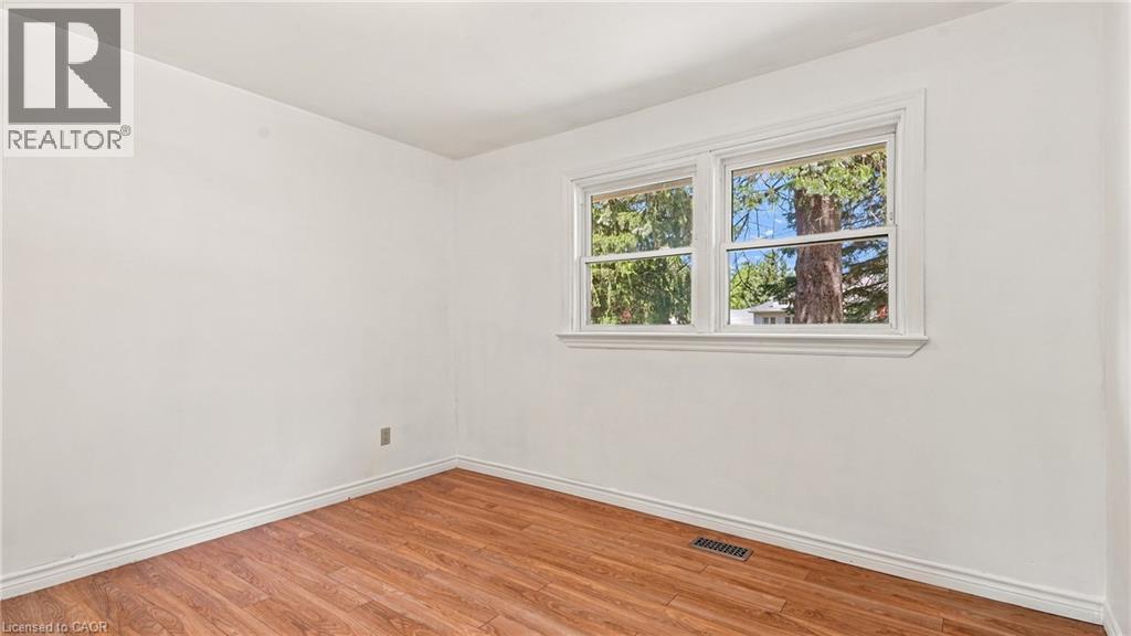 Room with wood-finish flooring, white walls, and white baseboards - 524 Dorval Drive, Ancaster, ON - Indoor Photo Showing Other Room