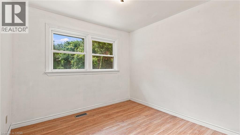 Room featuring a double window with white trim, wood-finish flooring, and white walls - 524 Dorval Drive, Ancaster, ON - Indoor Photo Showing Other Room