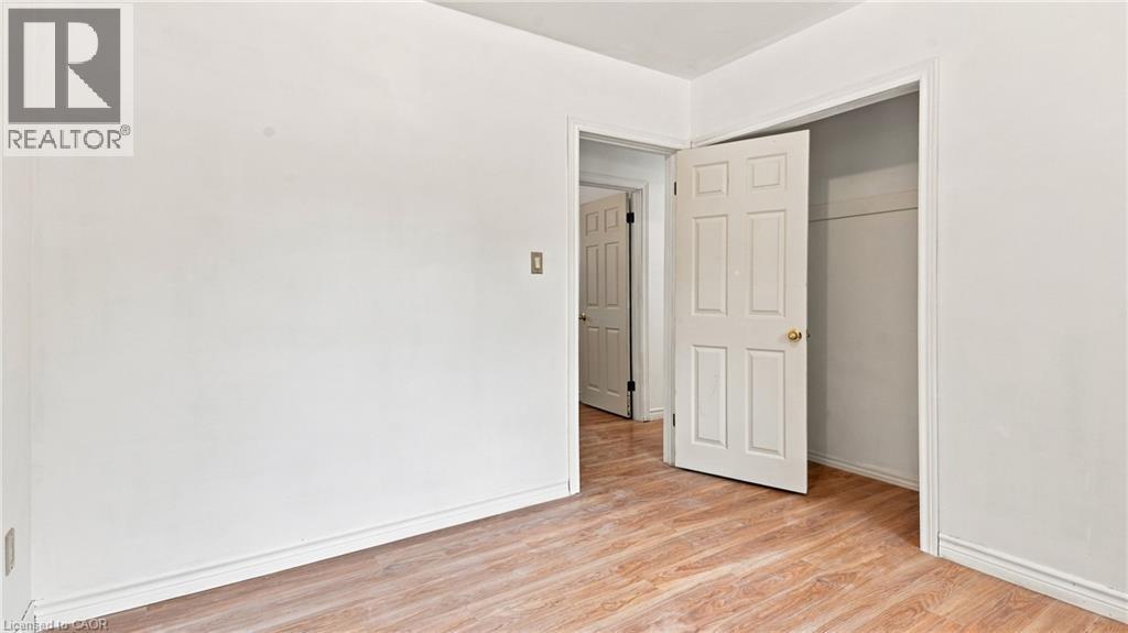 Interior room with light wood-finish flooring, white baseboards, and white walls - 524 Dorval Drive, Ancaster, ON - Indoor Photo Showing Other Room