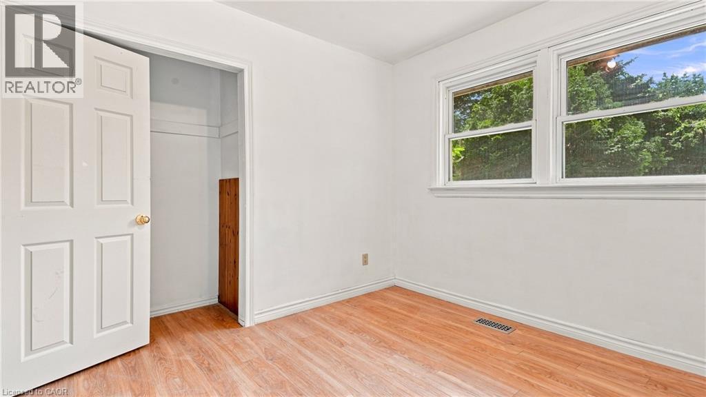 Bright interior space featuring wood-finish flooring, white baseboards, and white walls - 524 Dorval Drive, Ancaster, ON - Indoor Photo Showing Other Room