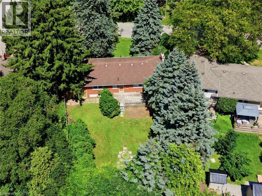 Terraced backyard with mature trees, green lawn, stone steps, and a multi-level deck - 524 Dorval Drive, Ancaster, ON - Outdoor
