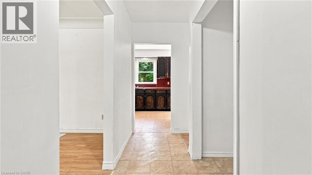 Hallway with neutral wall tones and diverse flooring, including light-toned wood-finish flooring and patterned floor tiles - 524 Dorval Drive, Ancaster, ON - Indoor Photo Showing Other Room