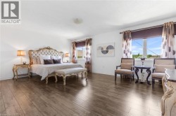 Spacious room featuring wood-finish flooring and white walls - 