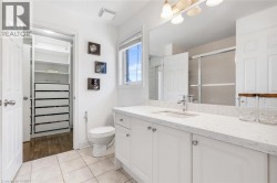 Bathroom featuring a white vanity with an integrated sink, a large mirror, and overhead lighting - 