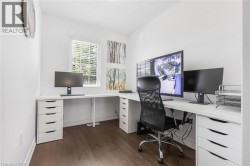 Interior room featuring wood-finish flooring, white walls, and a window with blinds - 