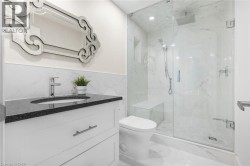 Contemporary bathroom featuring a frameless glass shower enclosure, a built-in shower bench, and a rainfall showerhead - 