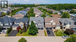 Contemporary residential streetscape featuring detached homes with varied architectural styles and front landscaping - 