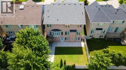 Brick exterior with bay window, rear patio, and expansive green lawn - 