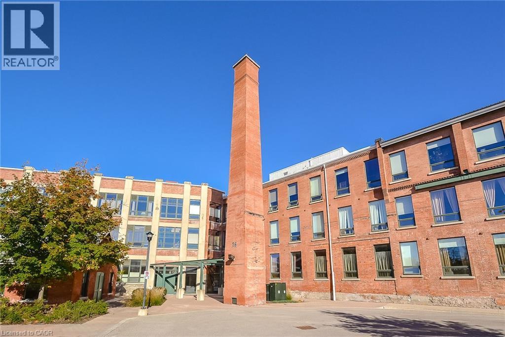 Brick facade building with a prominent brick chimney, multi-pane windows, and a covered entrance - 26 Ontario Street Unit# 127, Guelph, ON - Outdoor