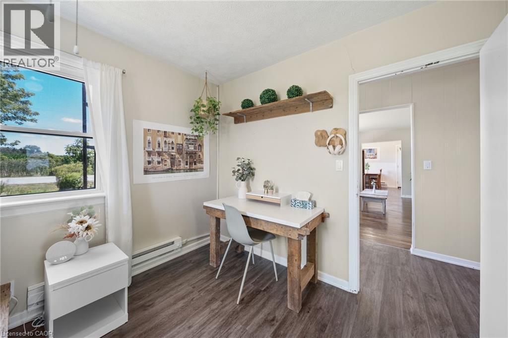 Space featuring wood-finish flooring, a window offering exterior views, and a doorway opening to an additional room - 3 Bousfield Lane, Jarvis, ON - Indoor