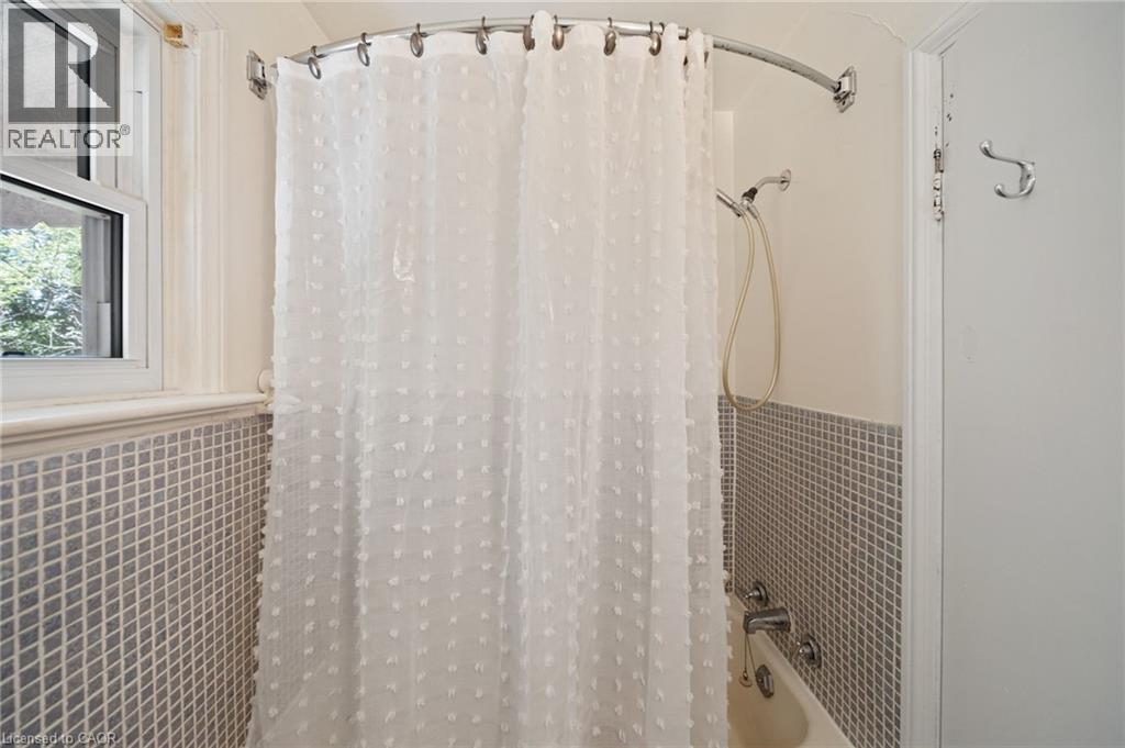 Bathtub with white subway tile surround, hand-held shower fixture, and an operable window - 3 Bousfield Lane, Jarvis, ON - Indoor Photo Showing Bathroom