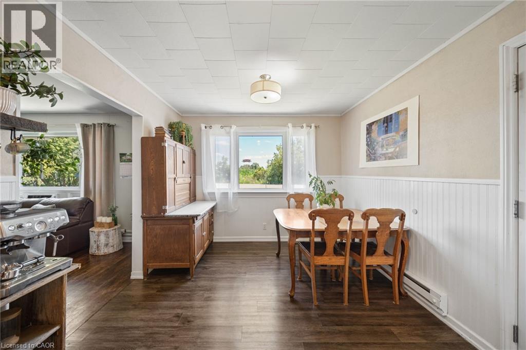 Dining area featuring wood-finish flooring, white beadboard wainscoting, and a ceiling light fixture - 3 Bousfield Lane, Jarvis, ON - Indoor Photo Showing Dining Room