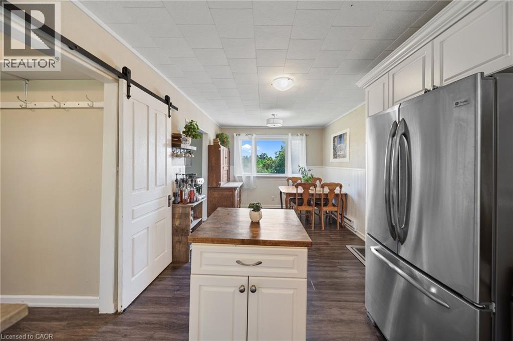 Kitchen featuring wood-finish flooring, white cabinetry with crown molding, and a stainless steel refrigerator - 3 Bousfield Lane, Jarvis, ON - Indoor Photo Showing Kitchen