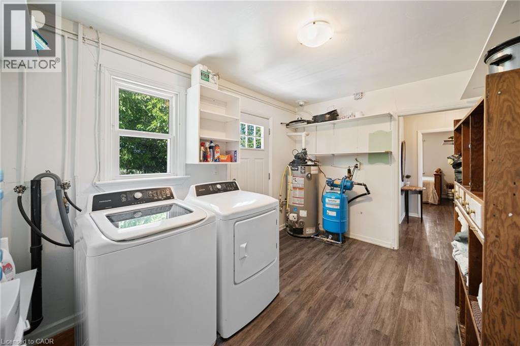 Utility space featuring wood-finish flooring, a window, and built-in shelving - 3 Bousfield Lane, Jarvis, ON - Indoor Photo Showing Laundry Room