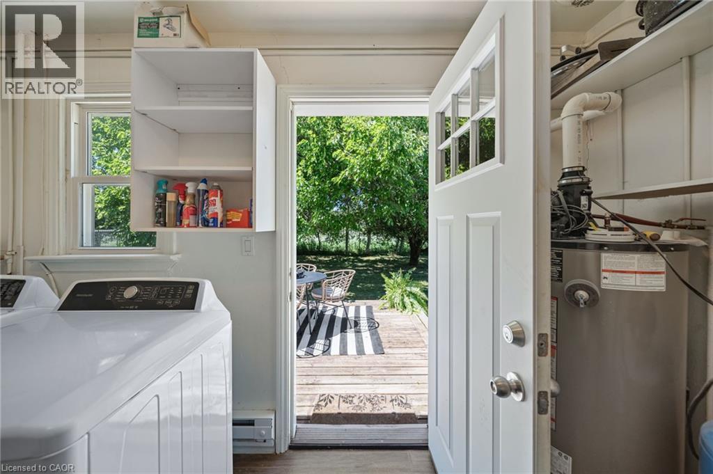 Laundry area featuring a top-load washing machine, wall-mounted cabinetry, and a window with natural light - 3 Bousfield Lane, Jarvis, ON - Indoor Photo Showing Laundry Room