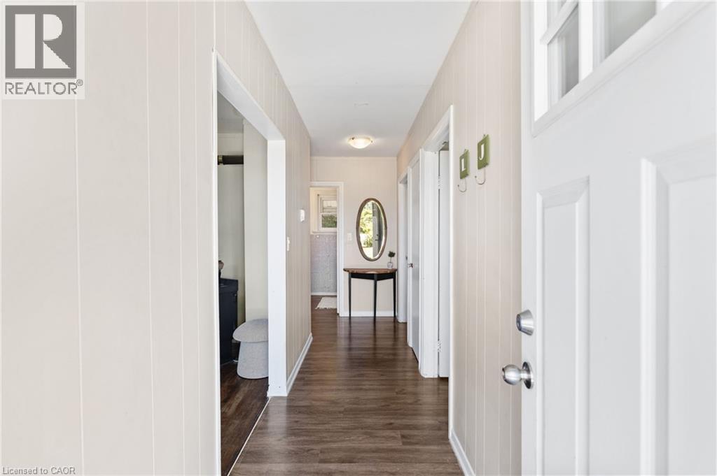 Entryway featuring a white paneled door with transom window, wood-finish flooring, and vertical wall paneling - 3 Bousfield Lane, Jarvis, ON - Indoor Photo Showing Other Room