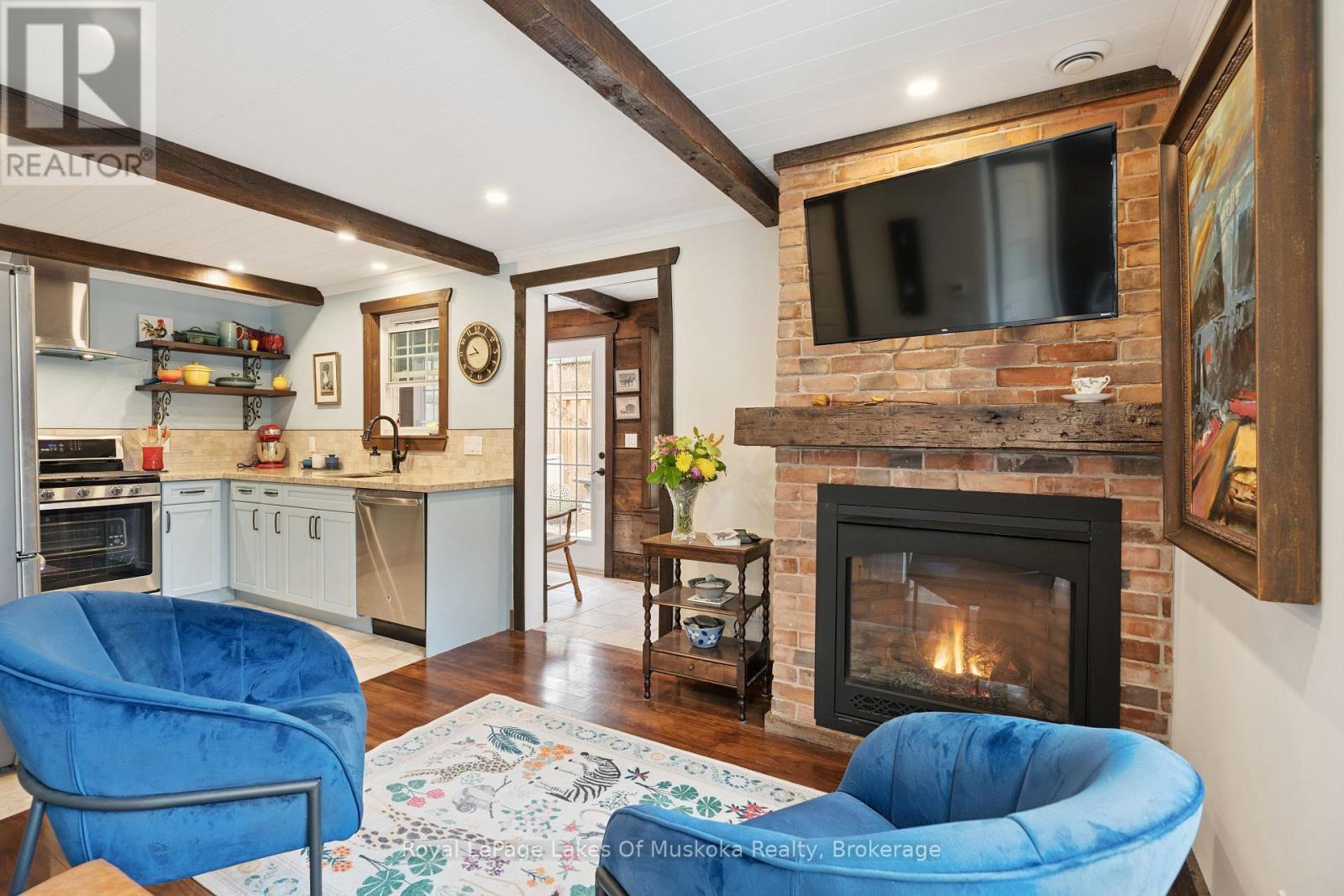 CARRIAGE HS: Living Area & Kitchen - 212 James Street, Bracebridge, ON - Indoor Photo Showing Living Room With Fireplace