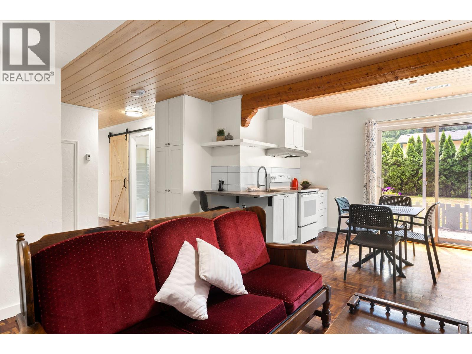 Lower lever with 2 separate entrances, sliding doors to back yard and side door entrance - 1587 Pratico Road, Revelstoke, BC - Photo Showing Living Room