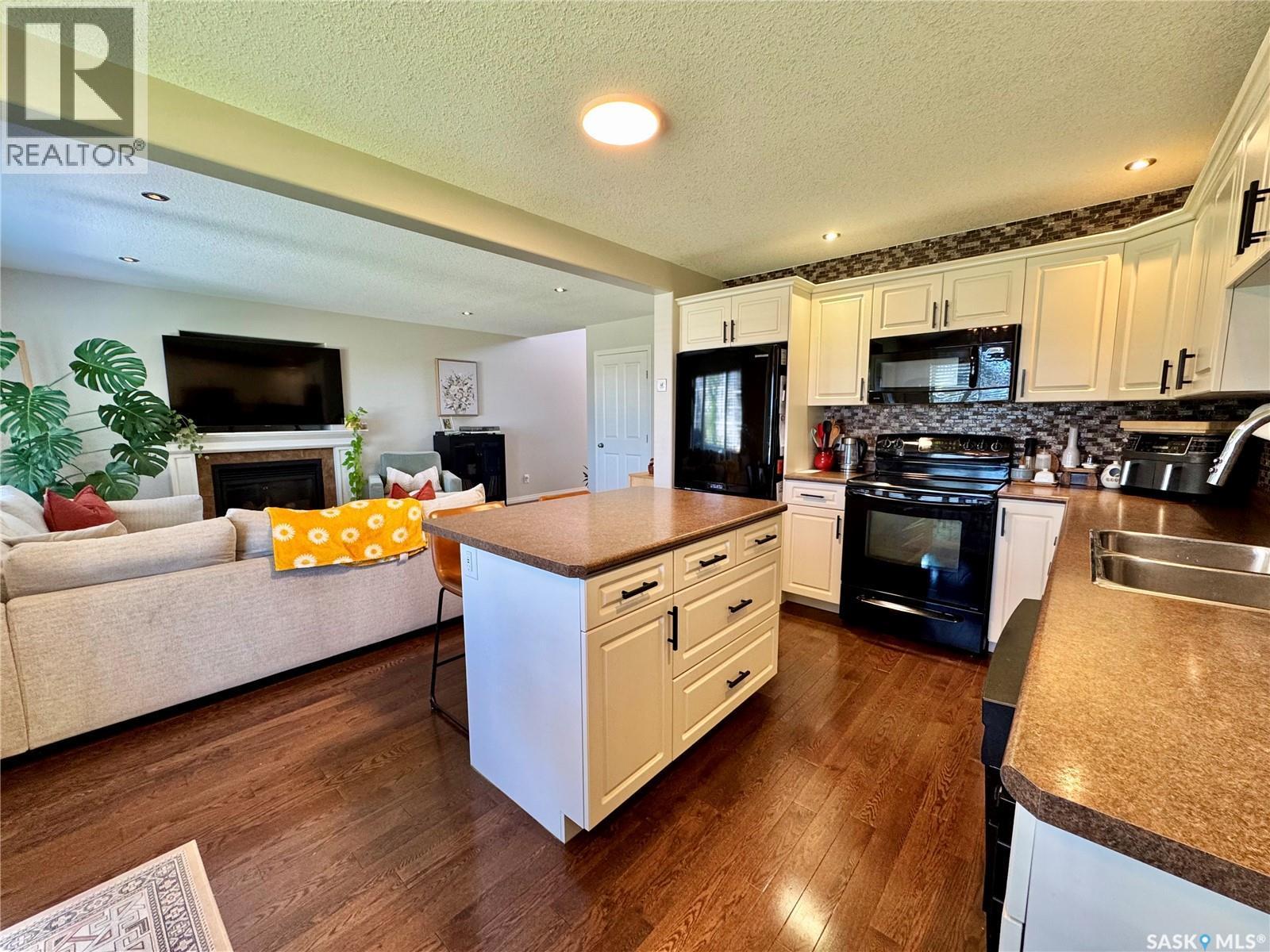 18 1600 Muzzy Drive, Prince Albert, SK - Indoor Photo Showing Kitchen With Fireplace With Double Sink