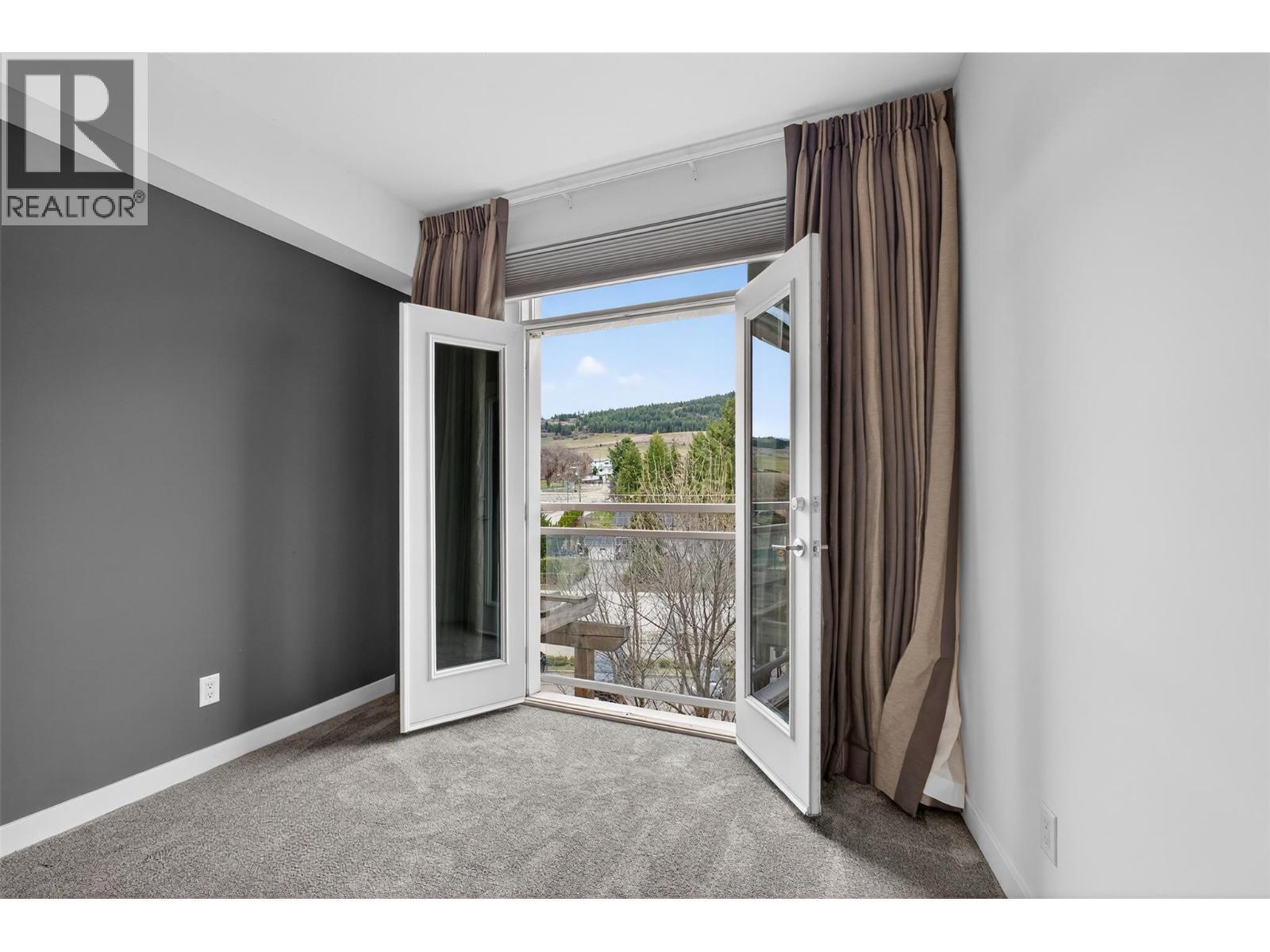 French Doors Open To Let In A Fresh Okanagan Breeze - 7343 Okanagan Landing Road Unit# 2402, Vernon, BC - Indoor Photo Showing Other Room
