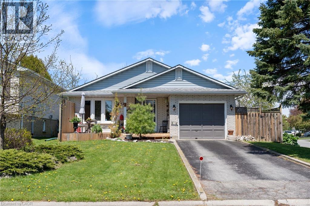 Bungalow-style residence featuring a light brick exterior and blue siding accents - 2 Hampton Court, Port Dover, ON - Outdoor With Deck Patio Veranda With Facade