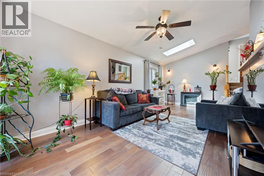 Living area featuring wood-finish flooring, vaulted ceiling, and a ceiling fan with integrated lighting - 2 Hampton Court, Port Dover, ON - Indoor Photo Showing Living Room