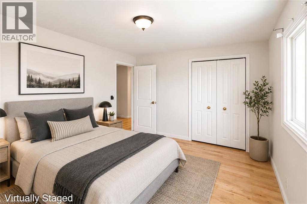 Light wood-finish flooring complemented by white trim and neutral wall paint - 100 Mountain Avenue N, Hamilton, ON - Indoor Photo Showing Bedroom