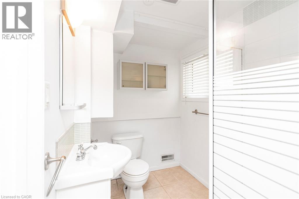 Bathroom featuring a pedestal sink with chrome fixtures, a tiled backsplash, and recessed wall cabinetry - 100 Mountain Avenue N, Hamilton, ON - Indoor Photo Showing Bathroom