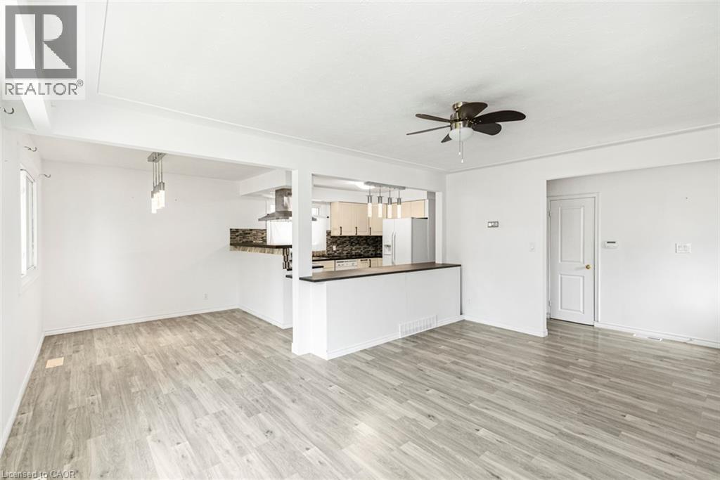 Open-concept living space featuring wood-finish flooring, white walls, and a ceiling fan - 100 Mountain Avenue N, Hamilton, ON - Indoor Photo Showing Kitchen