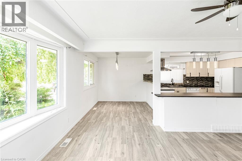 Open-concept living area with wood-finish flooring, white walls, and exposed ceiling beams - 100 Mountain Avenue N, Hamilton, ON - Indoor Photo Showing Kitchen