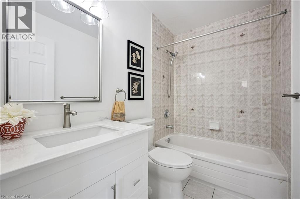 White vanity with an integrated rectangular sink, brushed nickel faucet, and a large mirrored medicine cabinet - 5147 Ravine Crescent, Burlington, ON - Indoor Photo Showing Bathroom