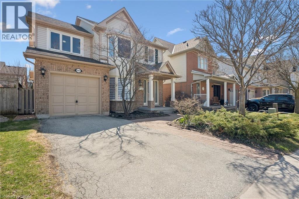 Two-story residence featuring a brick and siding exterior, an attached single-car garage, and a covered front porch with white railings - 5147 Ravine Crescent, Burlington, ON - Outdoor With Facade