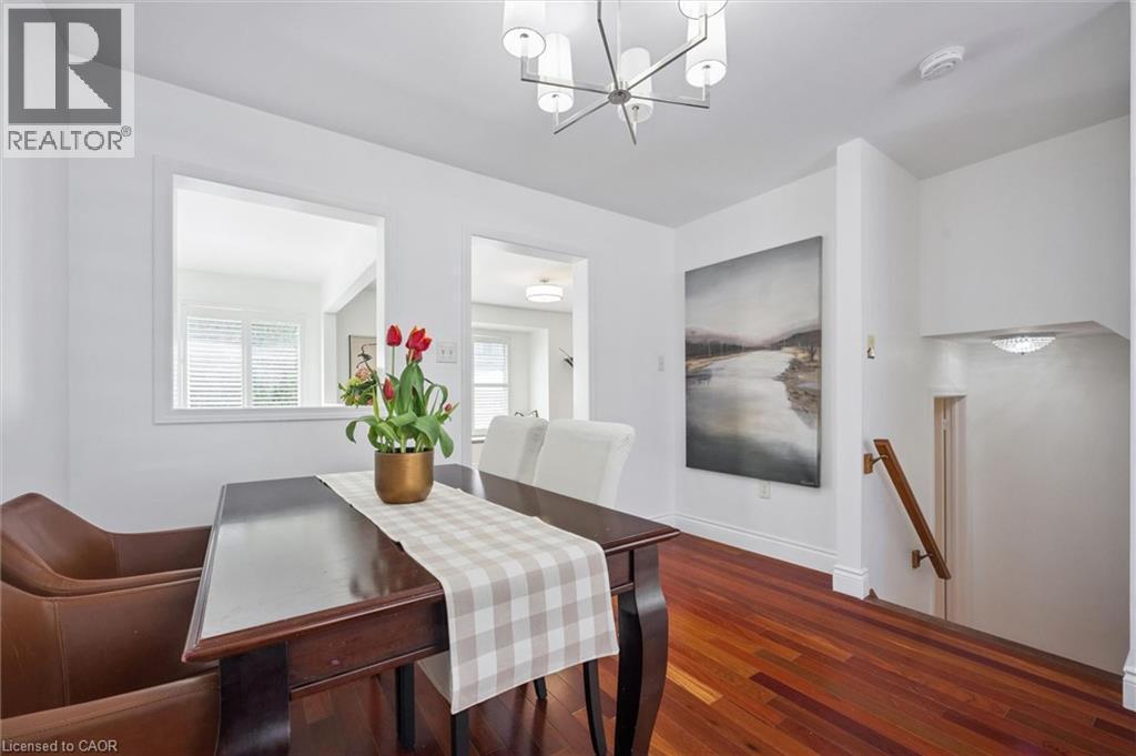 Dining area featuring rich wood-finish flooring, a contemporary chandelier, and an interior pass-through window - 5147 Ravine Crescent, Burlington, ON - Indoor Photo Showing Other Room