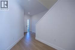 Entryway featuring light wood-finish flooring, recessed ceiling lighting, and a white paneled door -