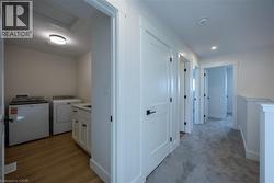 Dedicated laundry room with wood-finish flooring, built-in cabinetry, and a countertop -