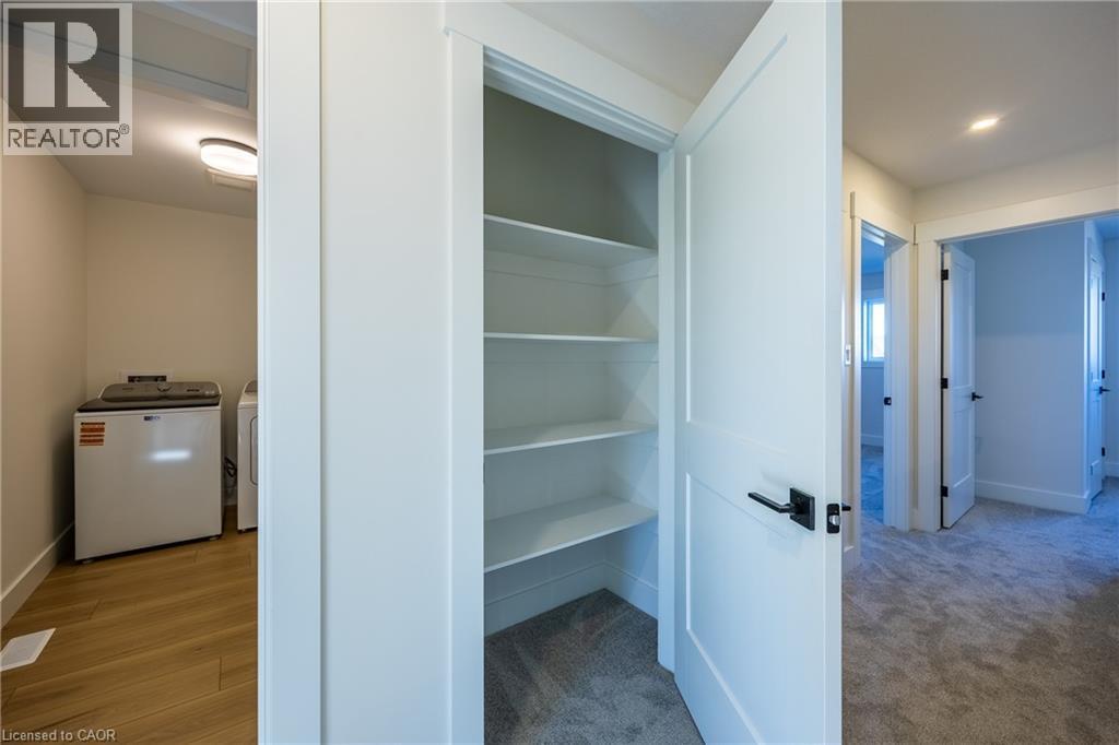 Spacious utility closet with white shelving, offering ample storage - 111 Amber Street, Waterford, ON - Indoor