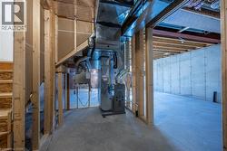 Unfinished basement featuring exposed framing, concrete flooring, foundational walls, and visible HVAC ductwork -