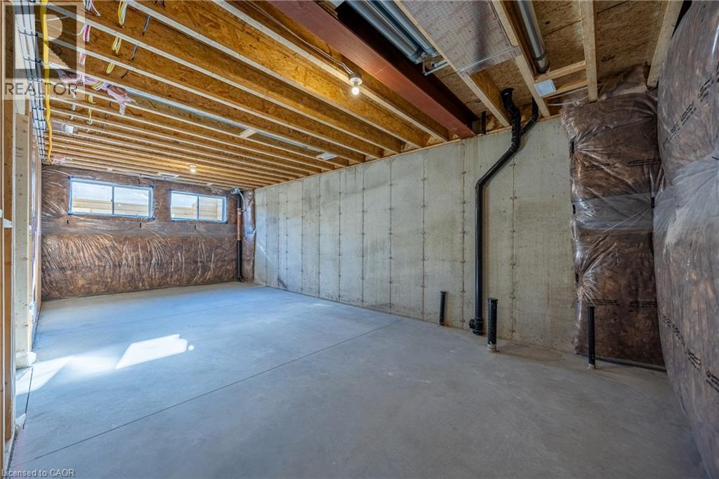 Unfinished basement space featuring exposed wood joists, concrete flooring, and multiple windows - 111 Amber Street, Waterford, ON - Indoor Photo Showing Basement
