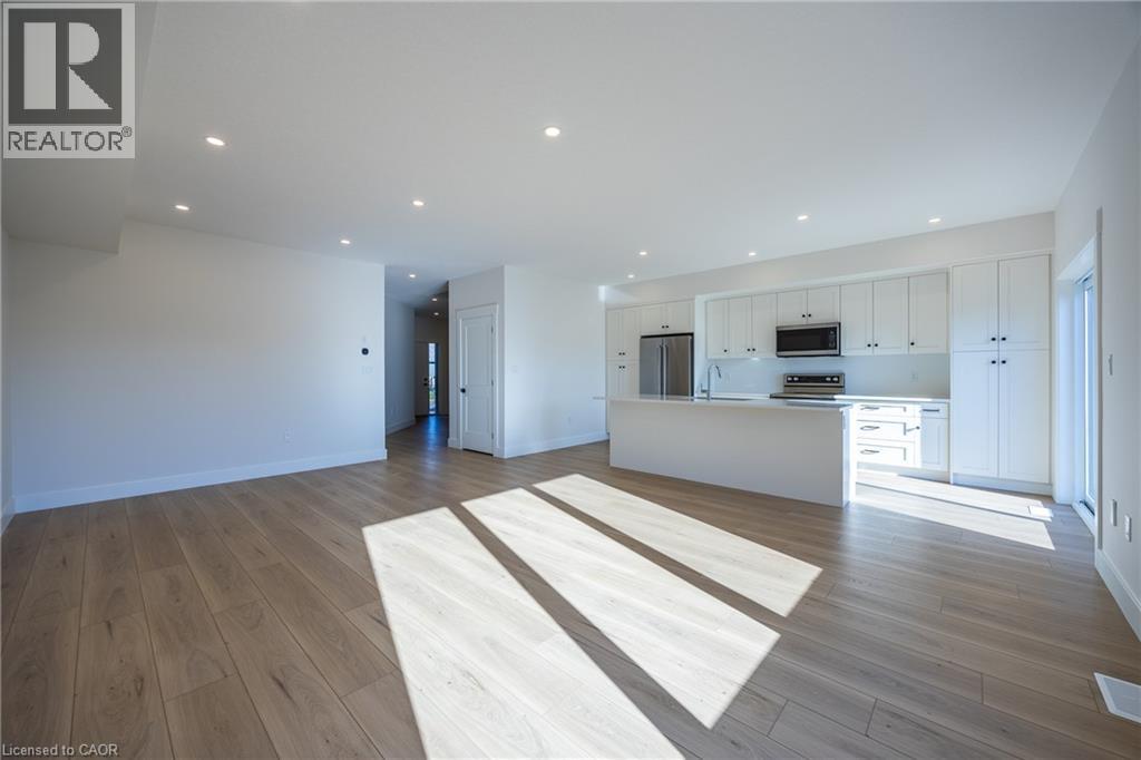 Open-concept living area featuring light wood-finish flooring, recessed lighting, and white baseboards - 111 Amber Street, Waterford, ON - Indoor Photo Showing Kitchen