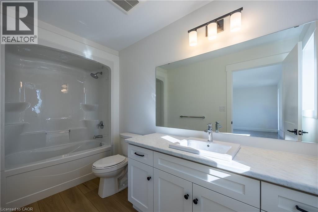 Bathroom featuring a white vanity with shaker-style cabinetry, a rectangular undermount sink, and a white countertop - 115 Amber Street, Waterford, ON - Indoor Photo Showing Bathroom