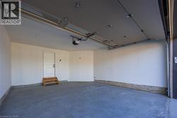 Spacious garage featuring a concrete floor, white painted walls, and a finished ceiling with an automatic opener -