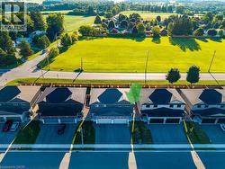 Detached property featuring a two-car garage, dark shingled roof, and light-colored siding -