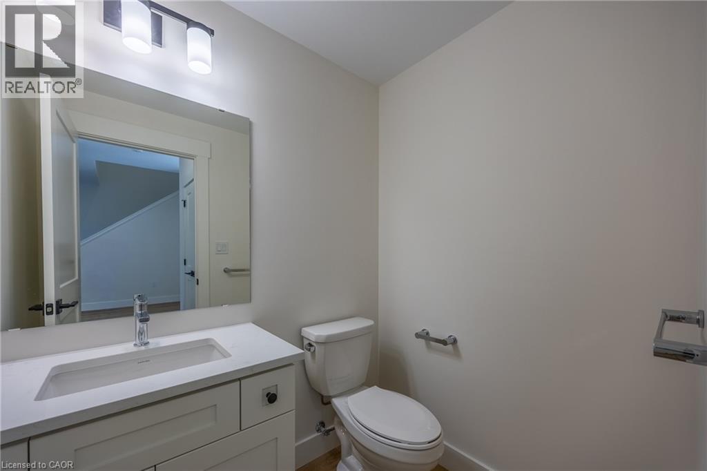 Bathroom vanity featuring a white rectangular undermount sink, a chrome single-handle faucet, and a light-toned countertop - 115 Amber Street, Waterford, ON - Indoor Photo Showing Bathroom