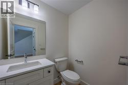 Bathroom vanity featuring a white rectangular undermount sink, a chrome single-handle faucet, and a light-toned countertop -