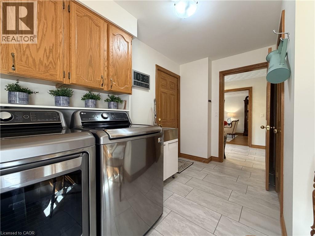 Main floor laundry with double closet and access to both the garage and patio on the side of the home. - 7 Mann Avenue, Simcoe, ON - Indoor Photo Showing Other Room