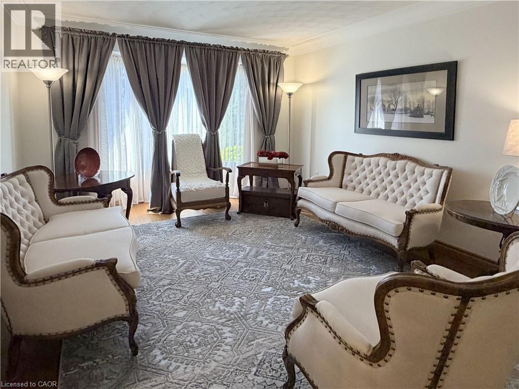 Formal living room faces the front of the home and features hardwood flooring, oversize windows, custom window coverings and glass doors tot he foyer. - 7 Mann Avenue, Simcoe, ON - Indoor Photo Showing Living Room