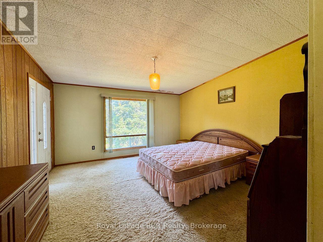 Main floor primary bedroom with water view. - 2 William Street, Northern Bruce Peninsula, ON - Indoor Photo Showing Bedroom